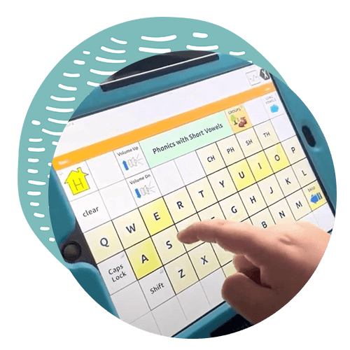 Close up of a screen of an assistive technology device displaying the keys of a computer keyboard. A finger appears to be close to touching the letter "s" on the screen.